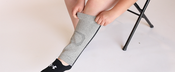 pulling the knee sleeve up the leg for placement on the knee