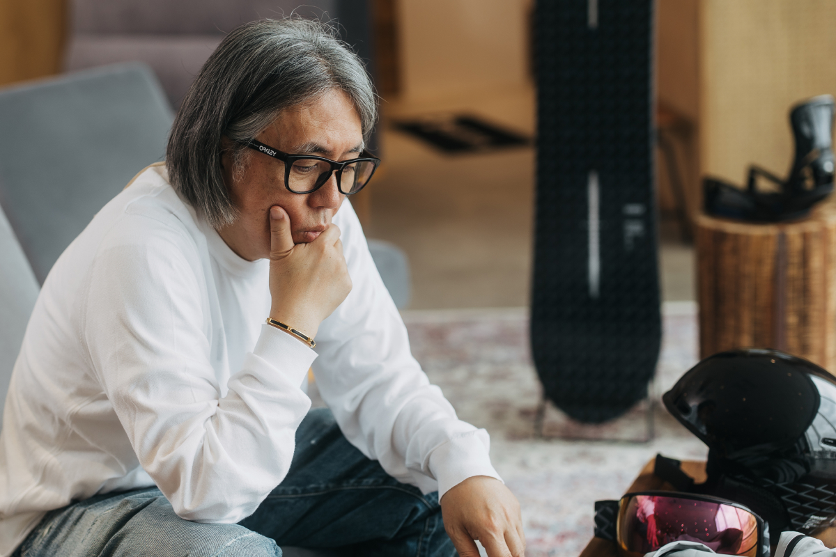Fragment founder, Hiroshi Fujiwara, sitting down surrounded by the Burton x Fragment collection