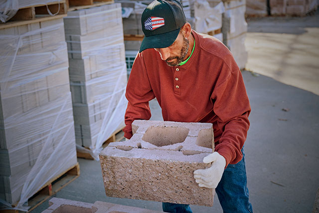 A man wearing the long sleeve waffle henley shirt in brown. Shop men's apparel.