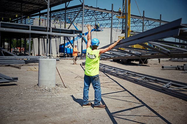 A worker on site wearing Staple Gun Carbon Comp Toe boot in brown. Shop men's safety and steel toe boots. 