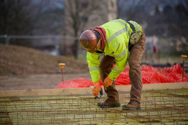 A man working and wearing the Gruntz Men's 6" Soft Toe Waterproof Work Boot in brown. Shop men's electrical hazard boots.