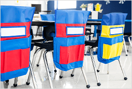 Classroom scene featuring student chairs with chairback buddies on them.