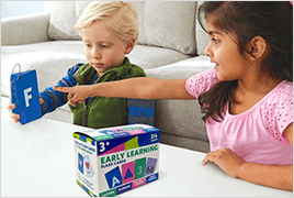 A young boy and girl at coffee table at home practicing with flash cards.
