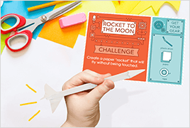 A hand holding a completed STEM Challenge learning card project.