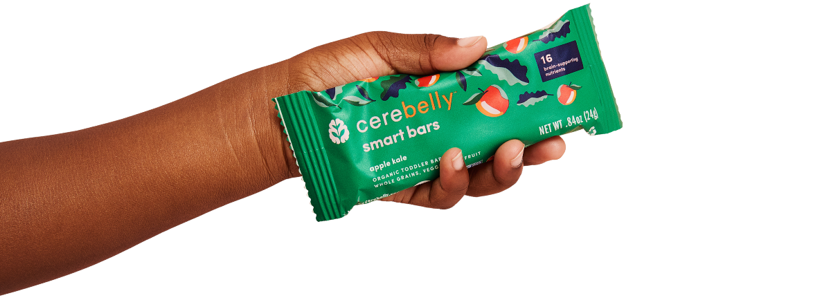 hand outstretched holding an apple kale smart bar