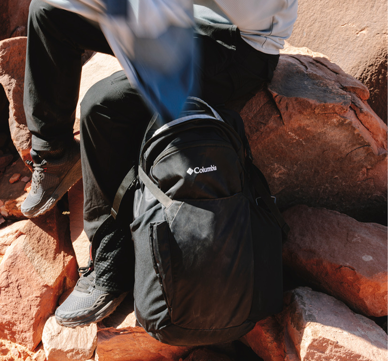 A close-up of a backpack laying on rocks.