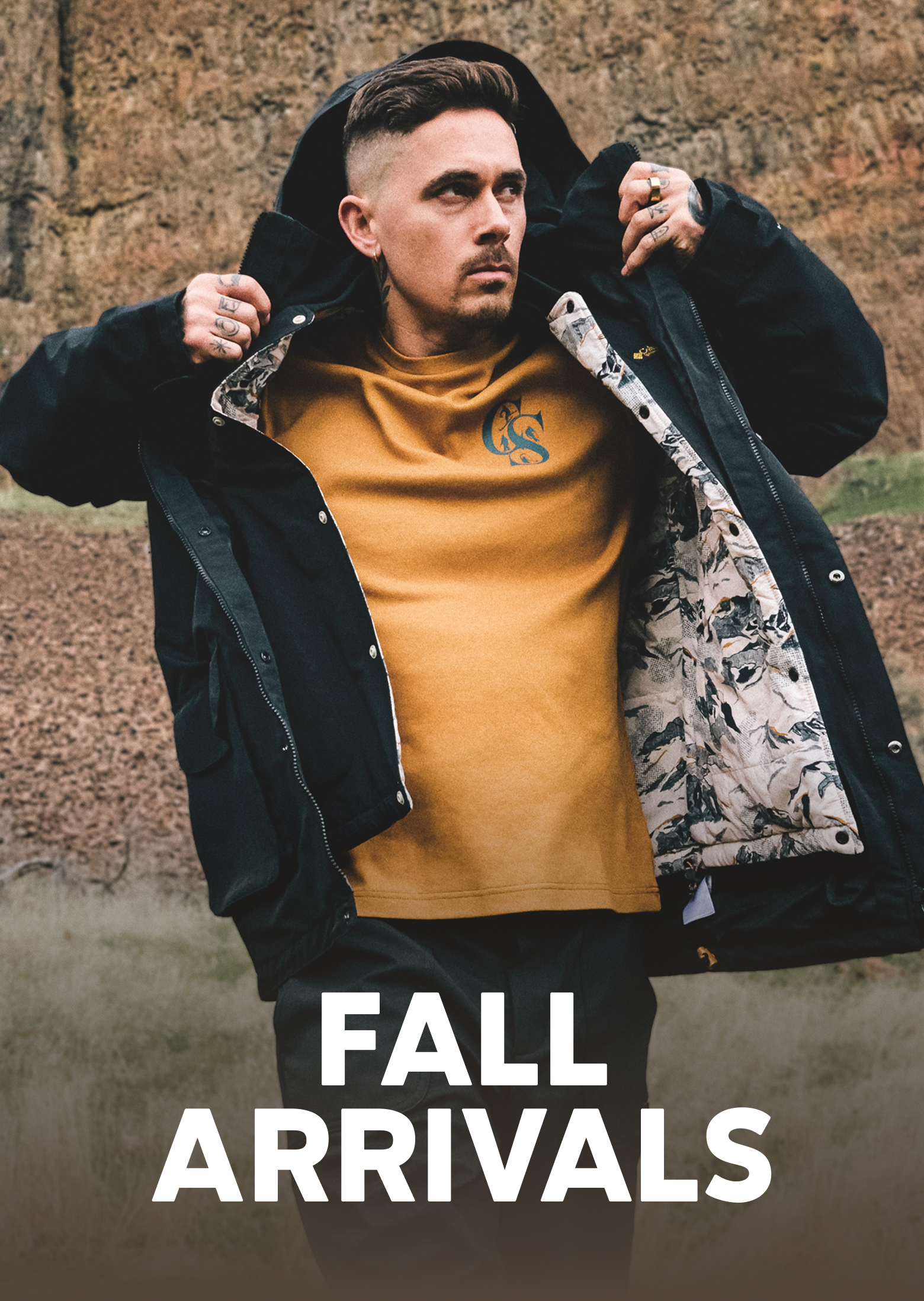 A man pulling on a jacket while walking outside with the text FALL ARRIVALS