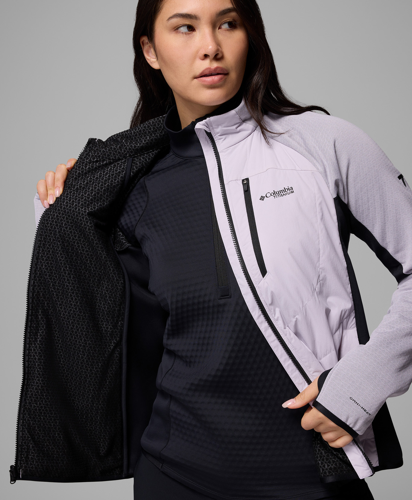 A woman opening her purple jacket.