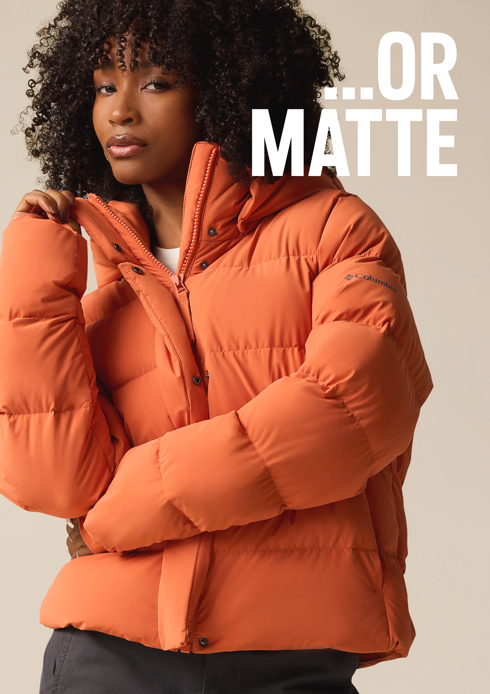 A woman wearing a puffy orange jacket with text: OR MATTE