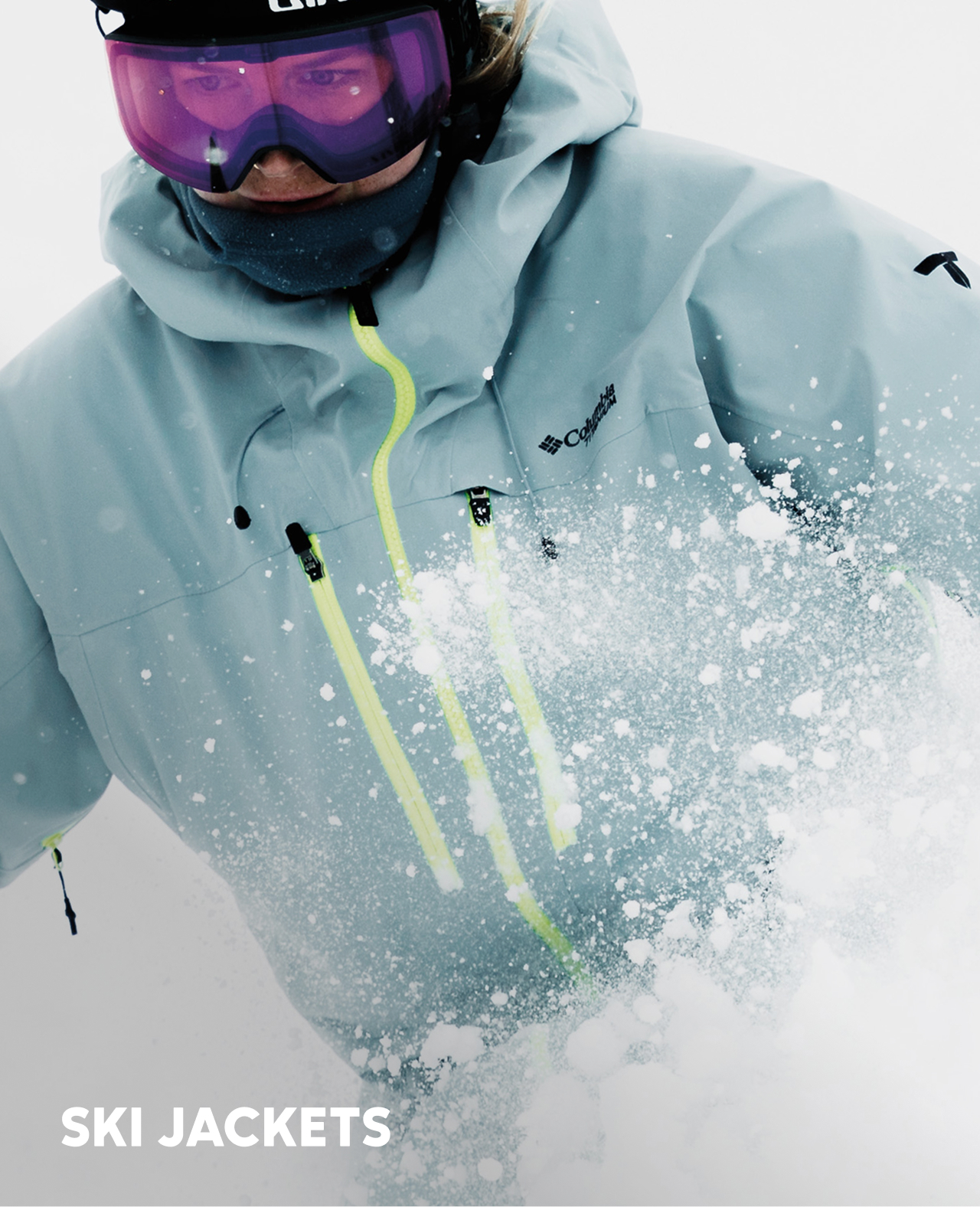 A skier in a blue jacket and helmet shredding through the snow.