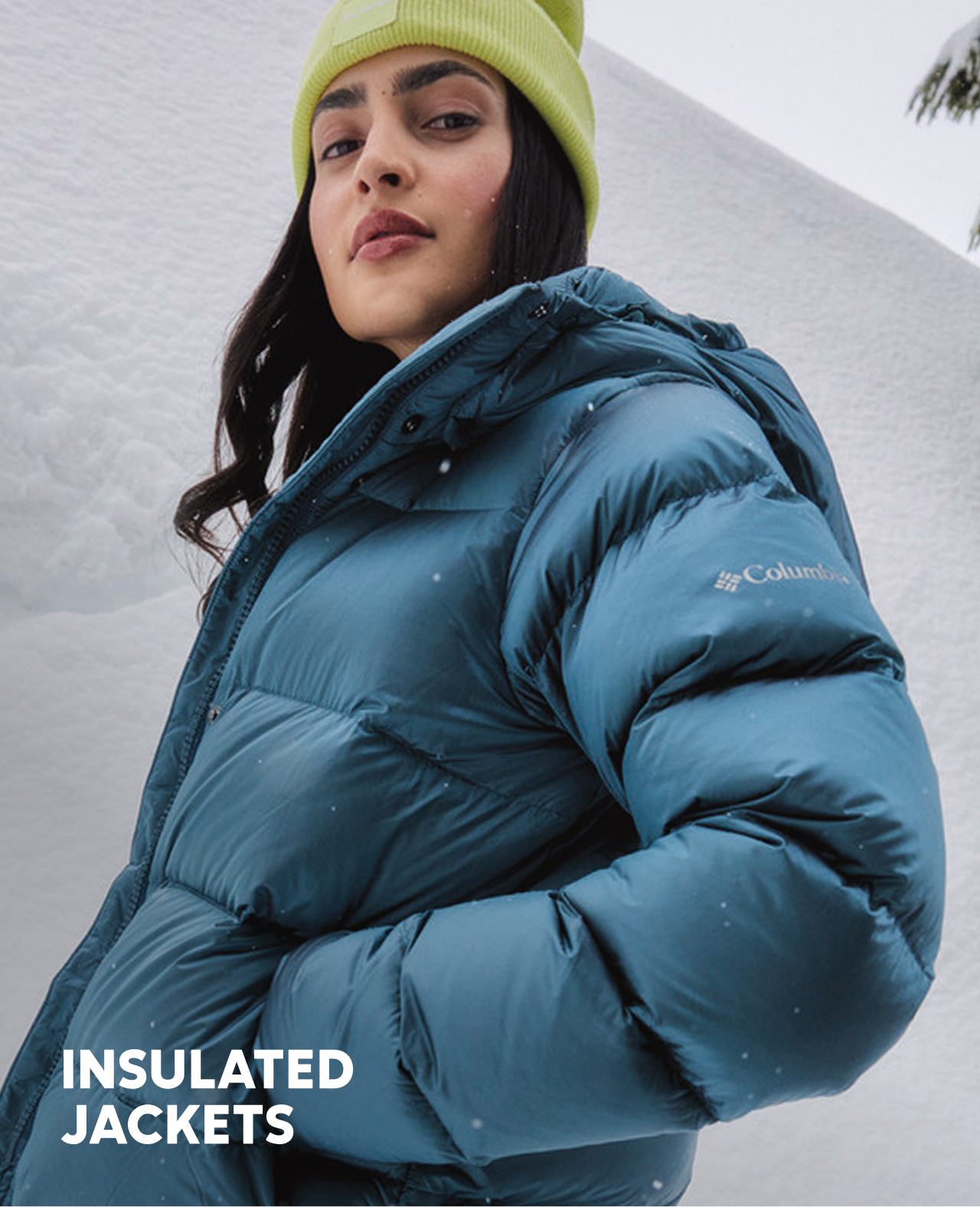 A woman wearing a blue puffer jacket in the snow.
