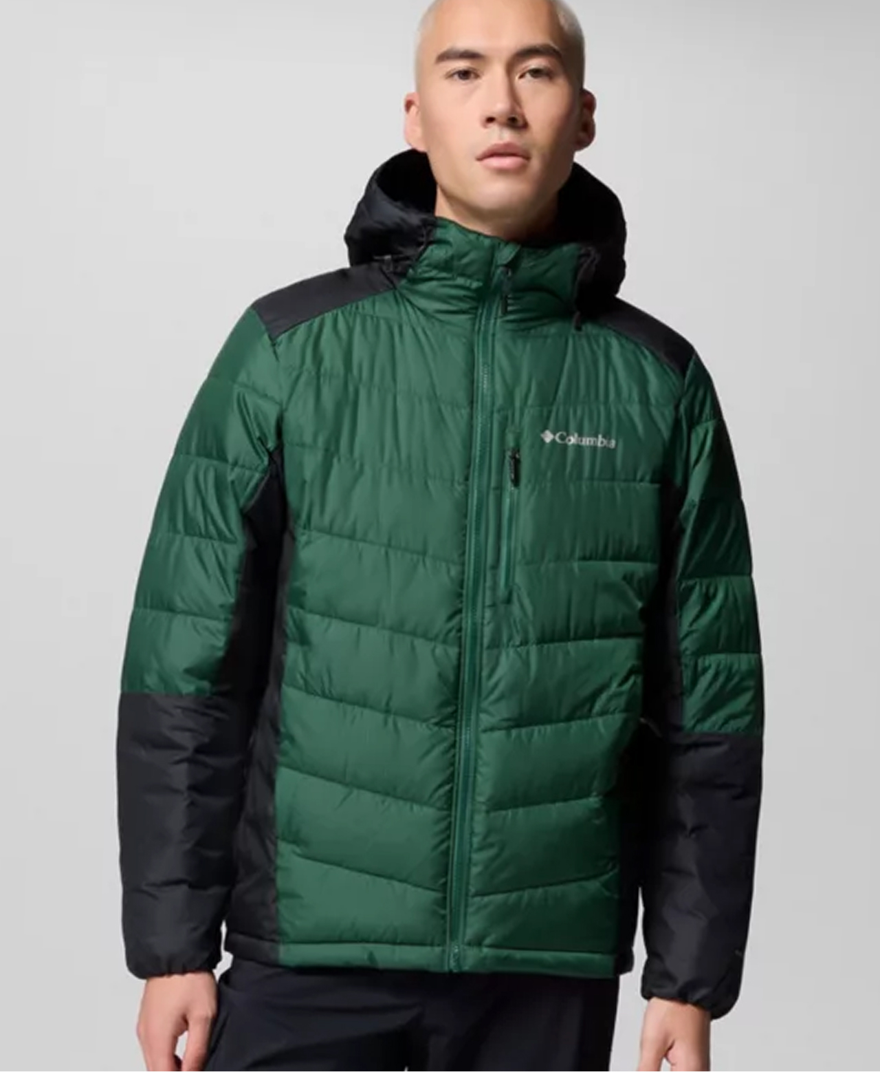 A man wearing a green puffer jacket.