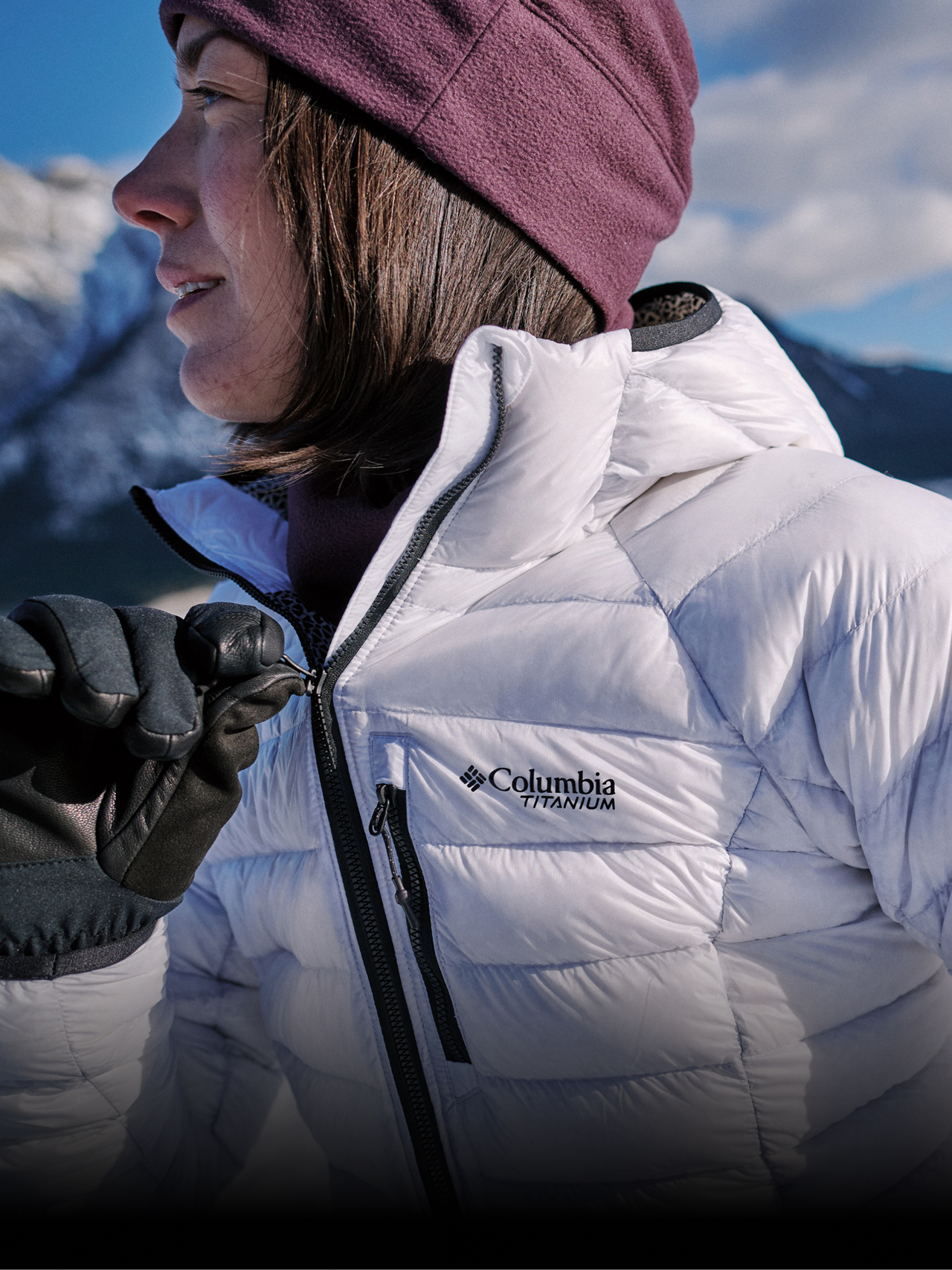 A woman wearing a white puffer jacket in a snowy mountain landscape with text: SERIOUS WARMTH