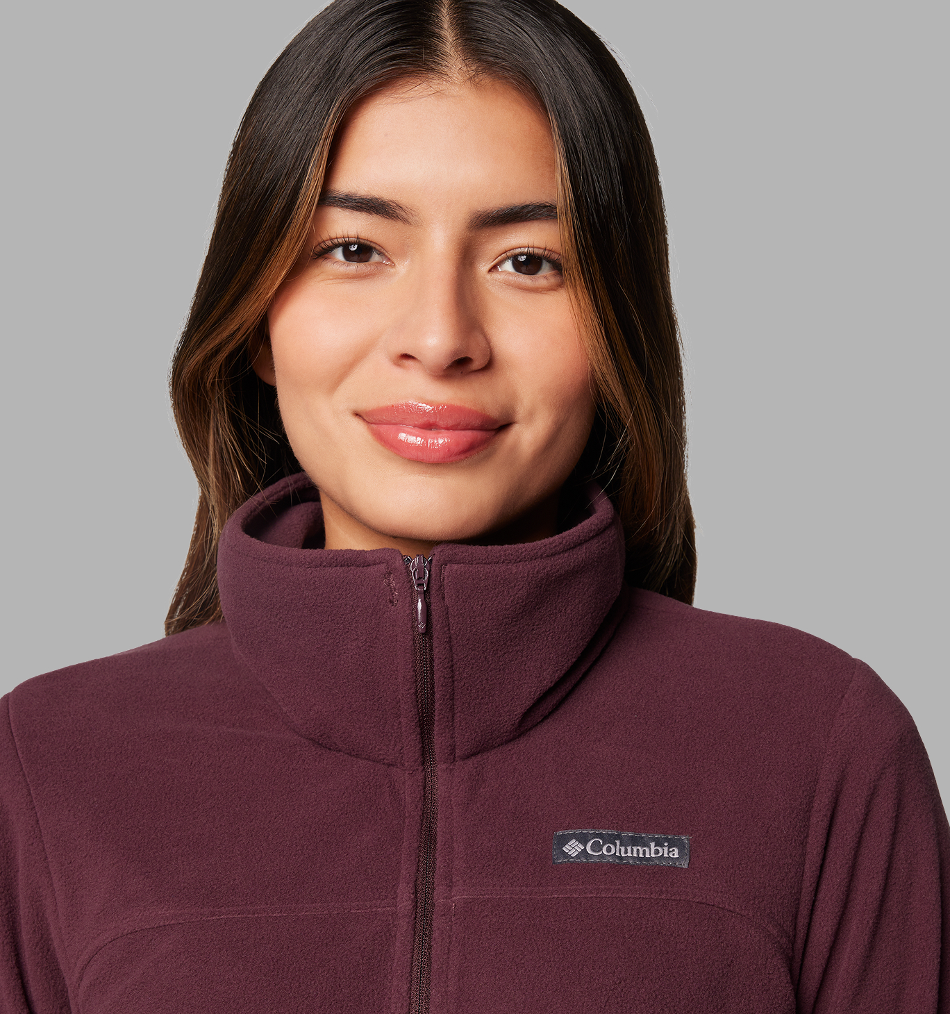 A woman wearing a maroon fleece hoodie with the hood up.