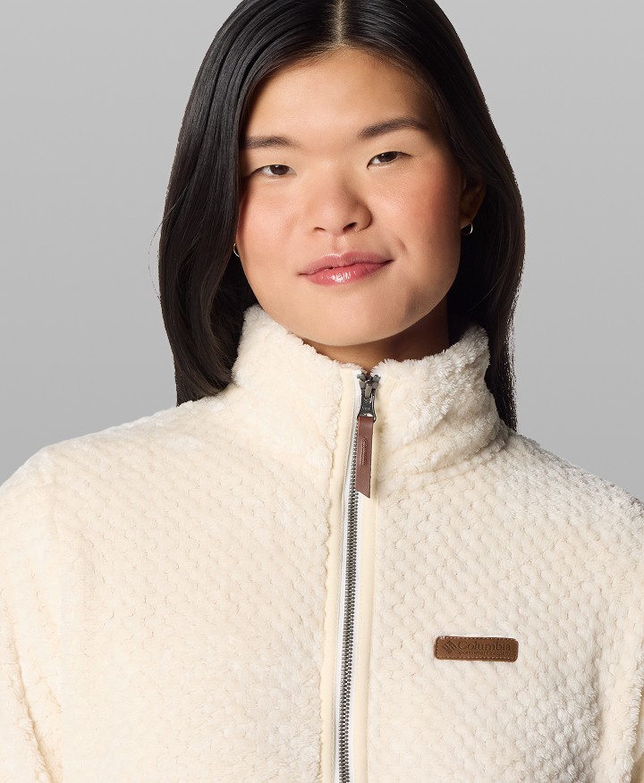 A woman wearing a white fleece zip-up.