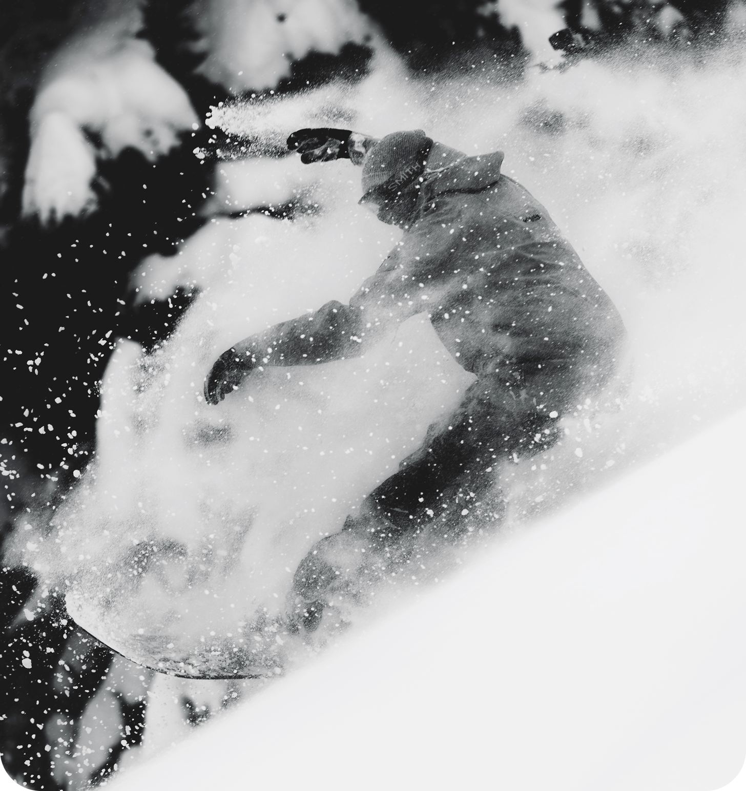 A black and white image of a skier flying down the mountain.