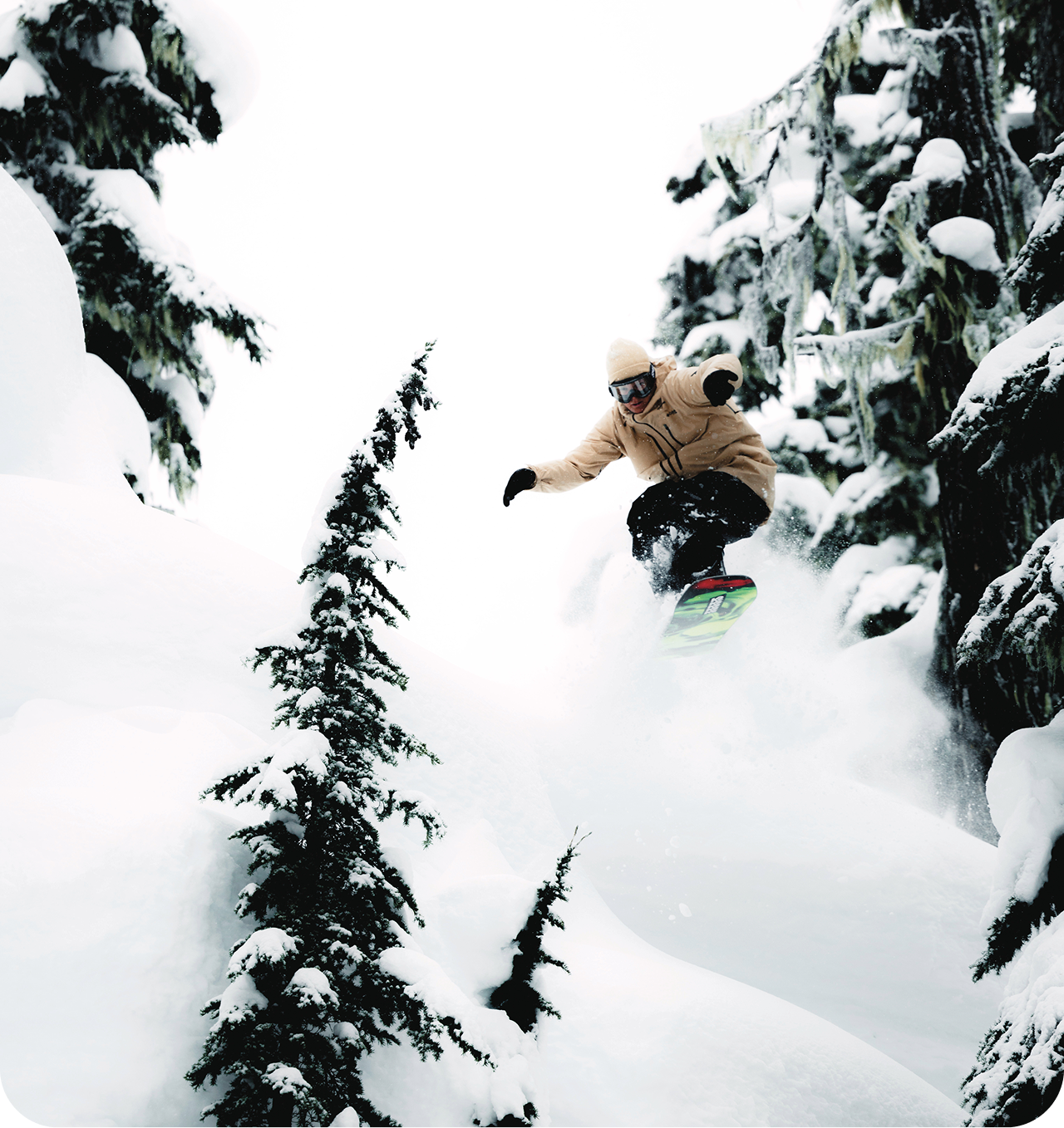A skier going down the mountain with tree tops in view.