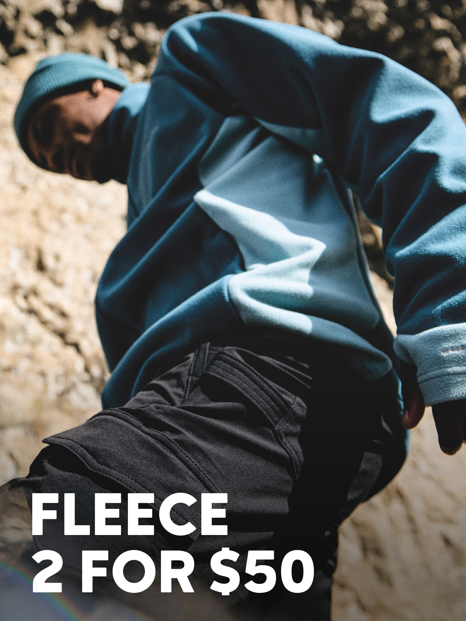 A man on a hike wearing a cozy fleece and beanie. Text says 2 FOR $50 FLEECE