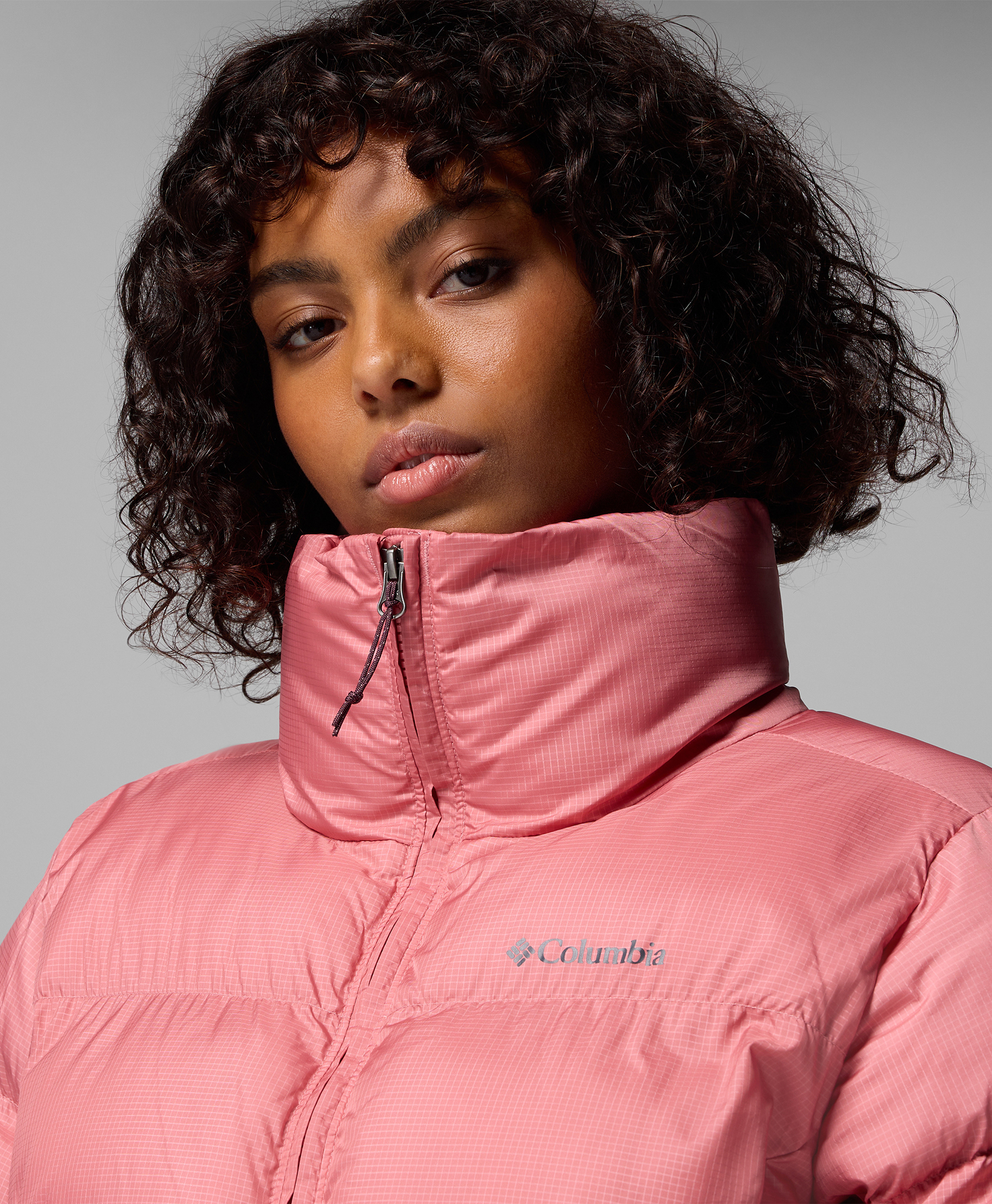A woman wearing a pink puffer jacket