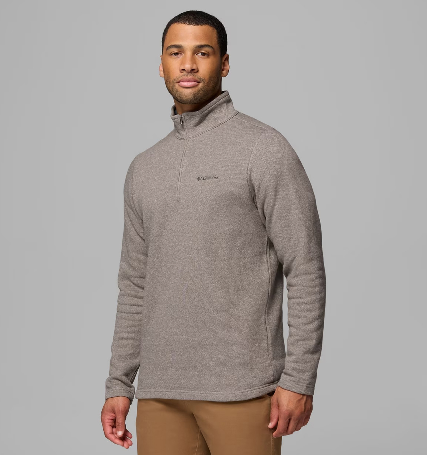 A man wearing a stone half zip