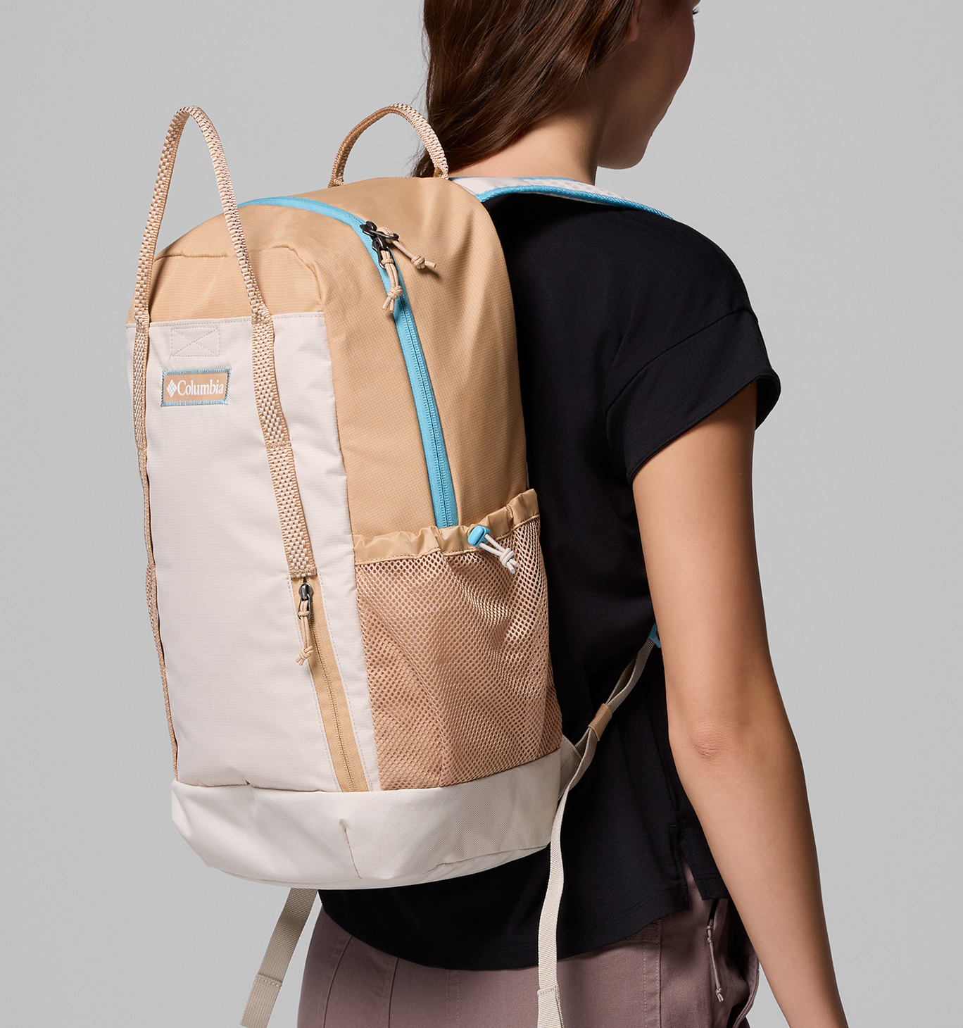 A woman wearing a tan backpack