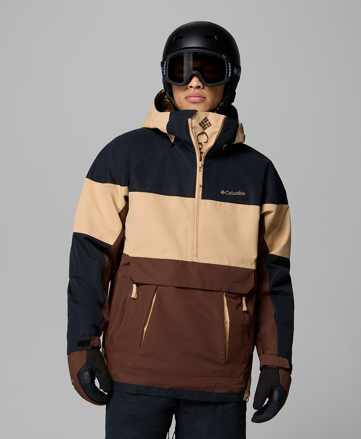 A person wearing a multi-color anorak with ski helmet and goggles