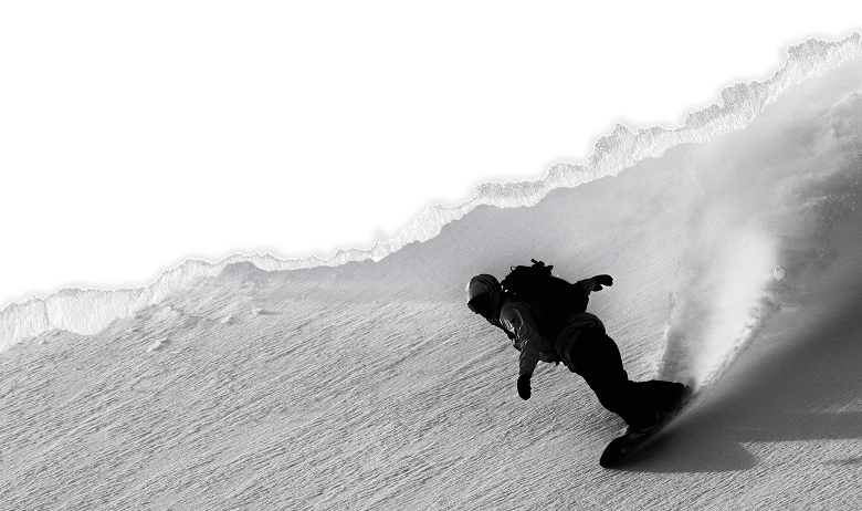 A snowboarder slashing through snow
