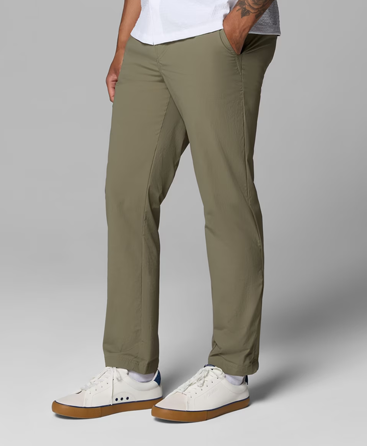 Waist-down image of a man wearing green pants and white sneakers.