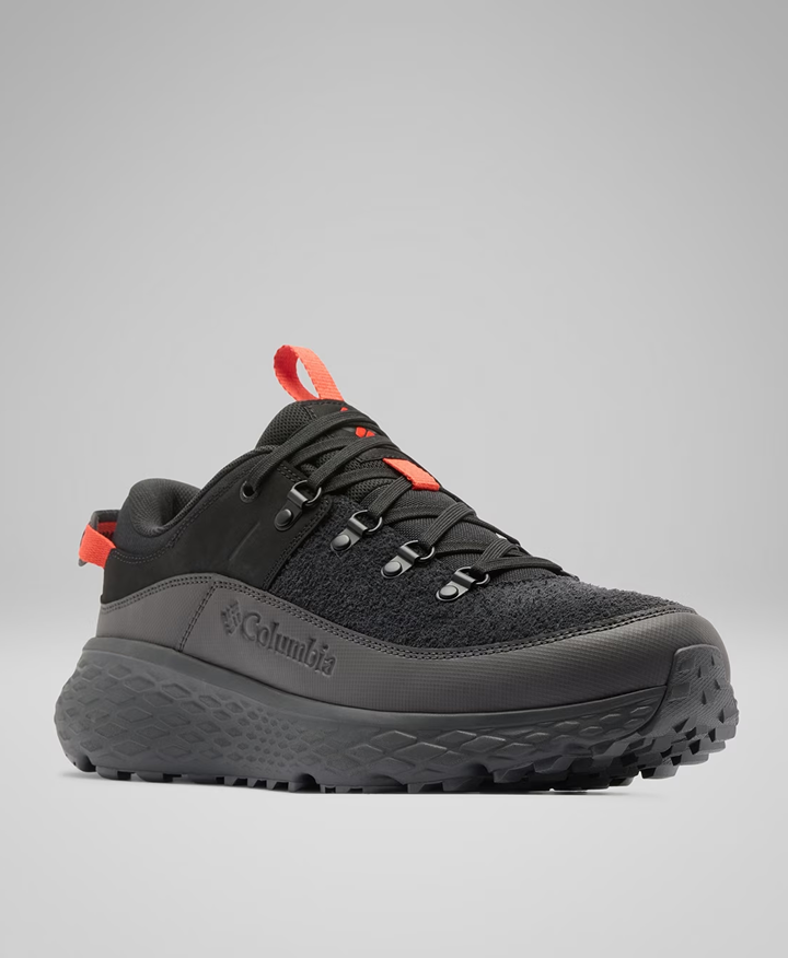 A black hiking shoe with red accents.