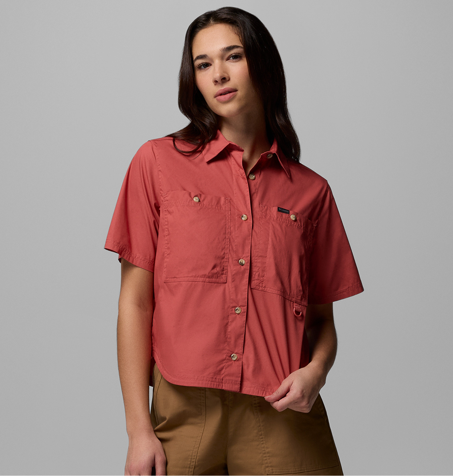 A woman wearing a red short sleeve button-up shirt.