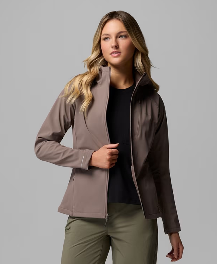 A woman wearing a mauve jacket, a black shirt, and olive green pants.