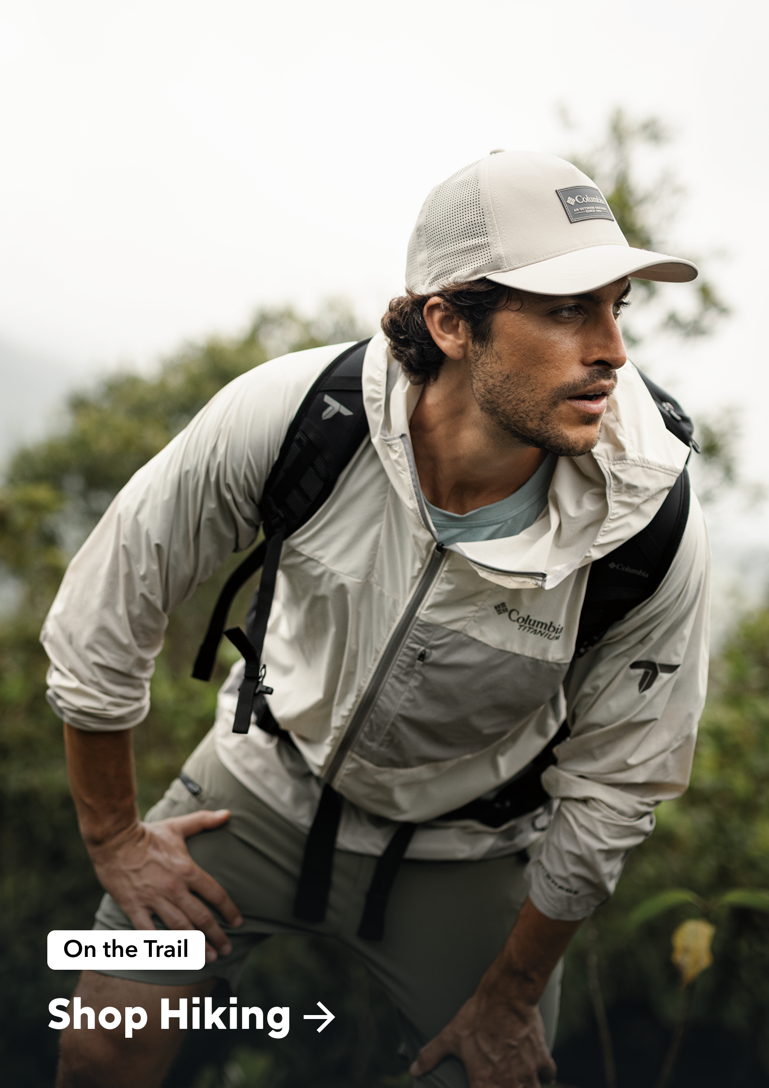 A man hiking on a trail and intensely looking at the trail ahead.