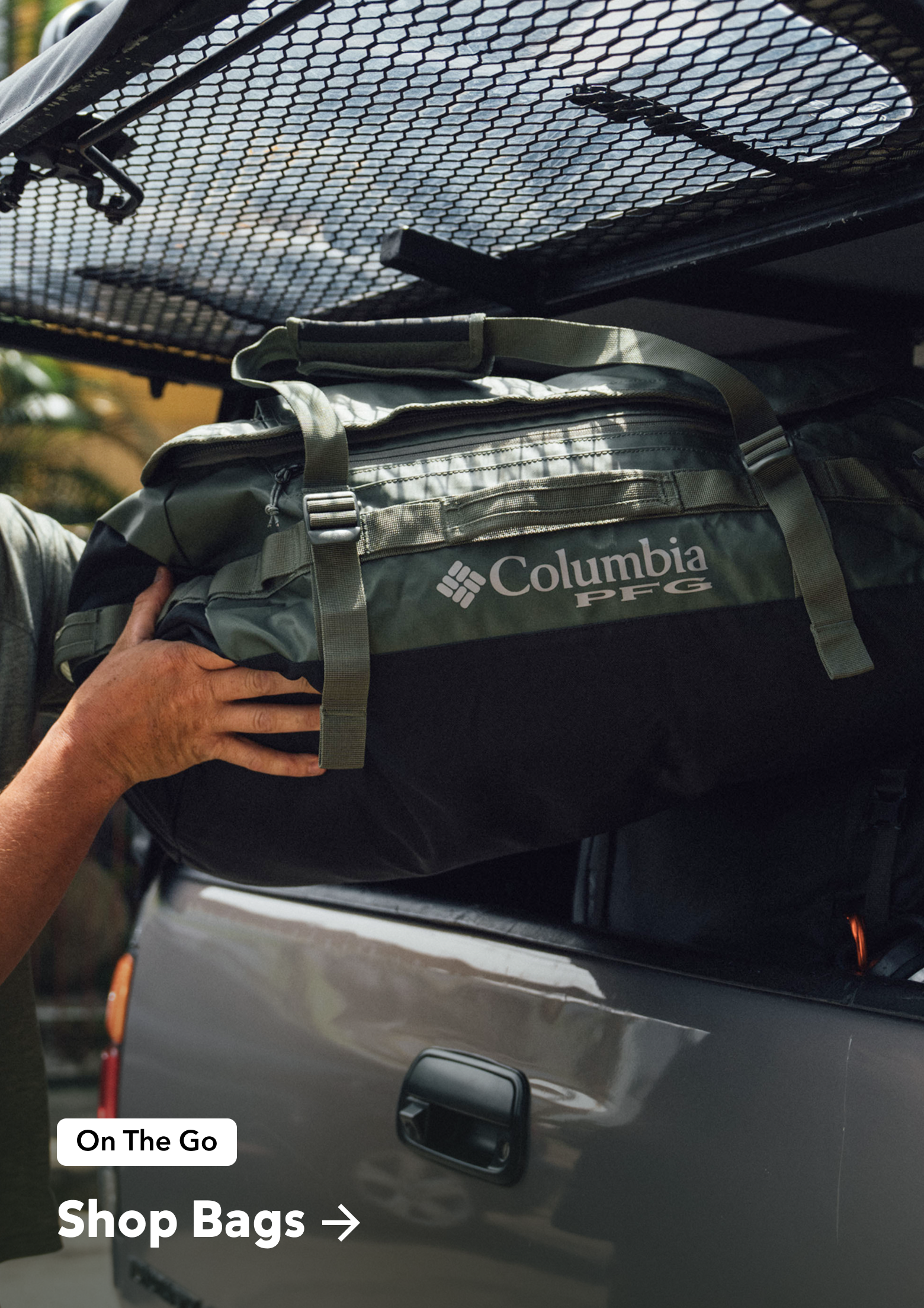 A man storing his Columbia PFG duffel bag into the back of his truck. 