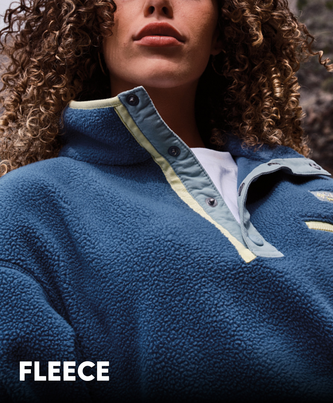 A woman wearing a blue fleece pullover with text: FLEECE