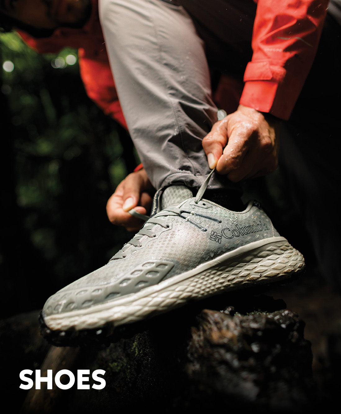 Close-up of a man tying his grey hiking shoes in the rain with text: SHOES