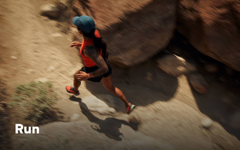 Aerial shot of a woman running on a desert trail with text: Run