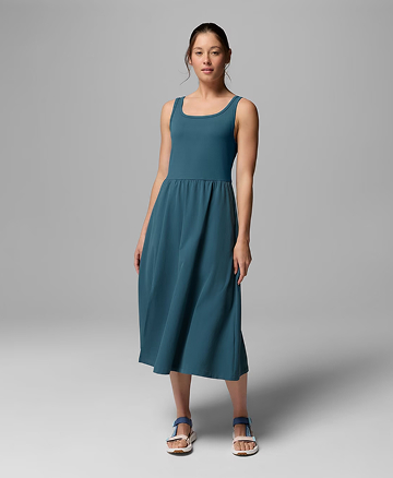 A woman wearing a teal dress and sandals.