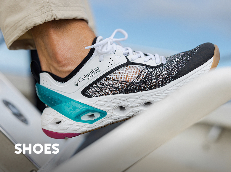 Close-up of someone's white sneaker on the deck of a boat with text: SHOES