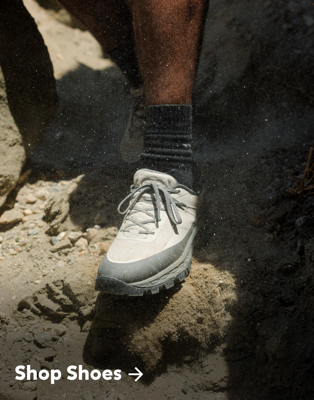 Image of a shoe stepping on a dirt trail with specks of dirt flying up