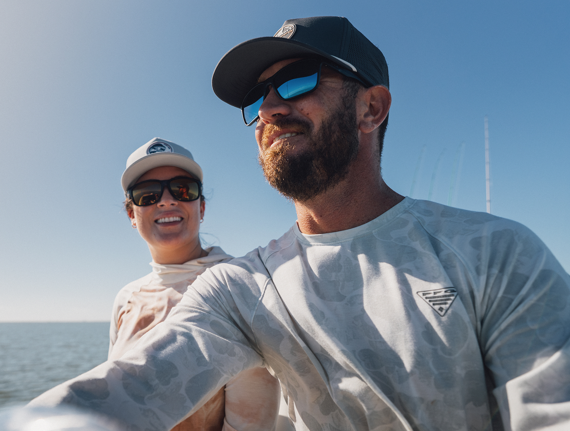 A man and woman smiling on a boat.