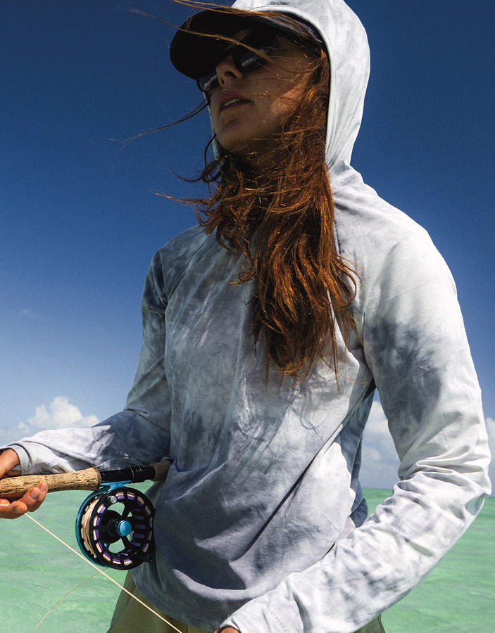 A woman fishing in a tropical environment.