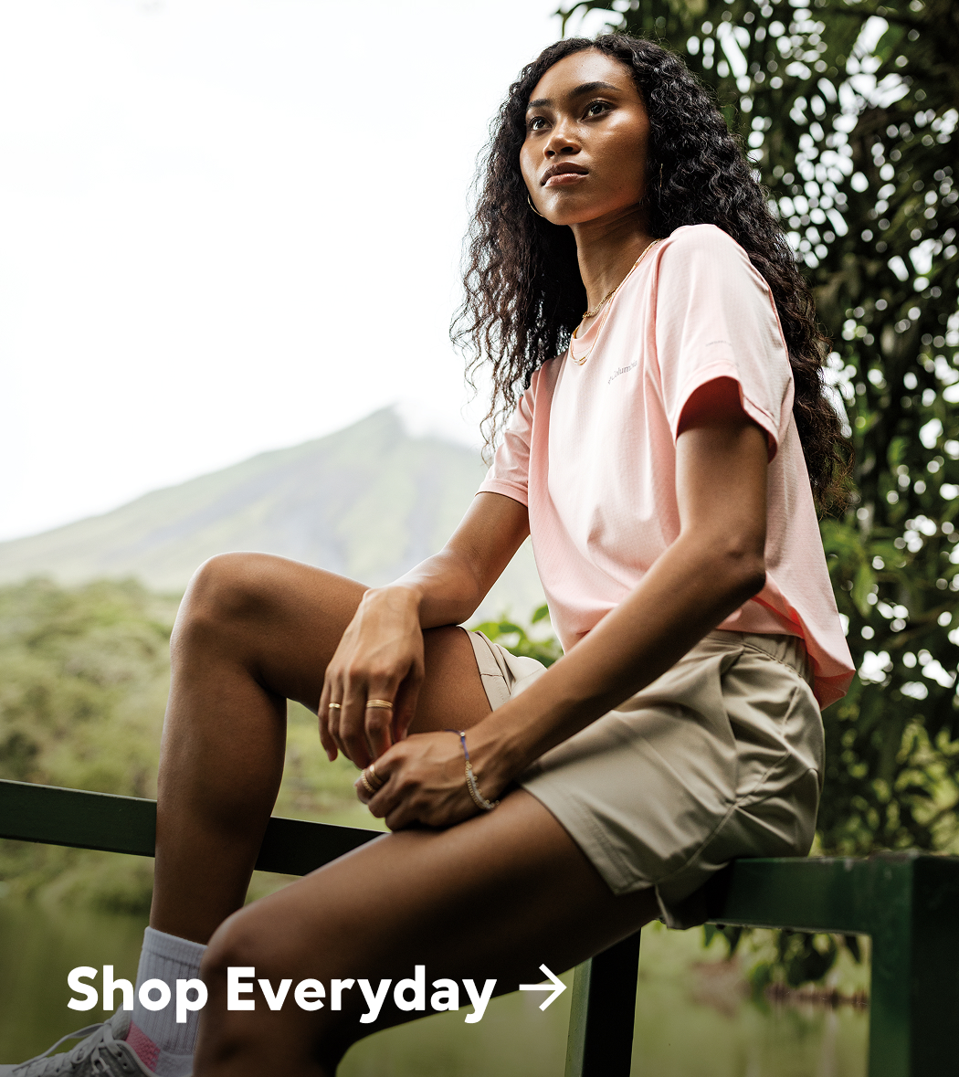 Shop Everyday over an image of a woman sitting on a fence with a mountain in the background