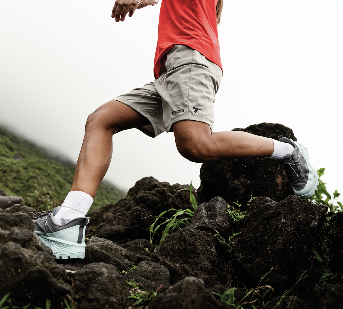 A waist down image of a person trail running over rough terrain