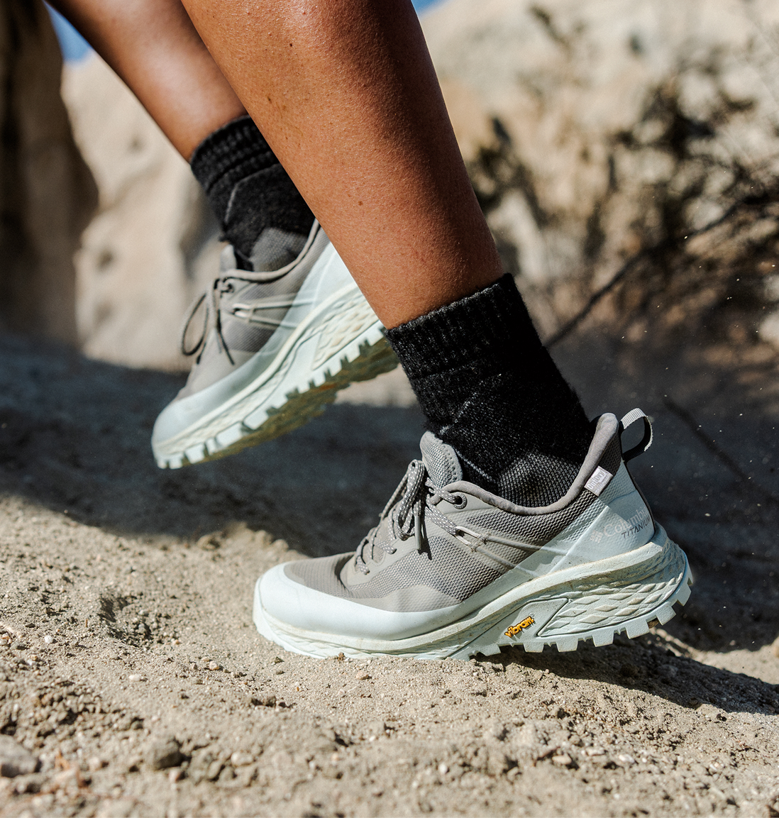 A woman standing on a rock with her Konos TRS shoe.
