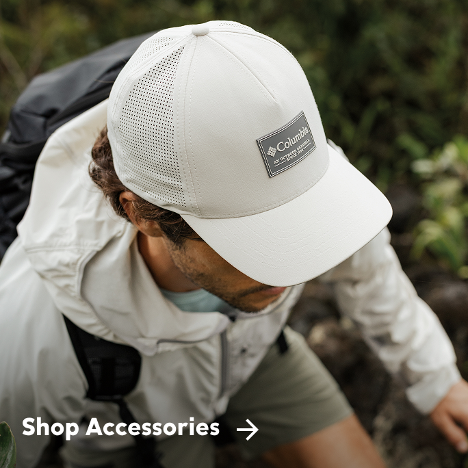 Image of a man hiking, wearing a Columbia hat. 