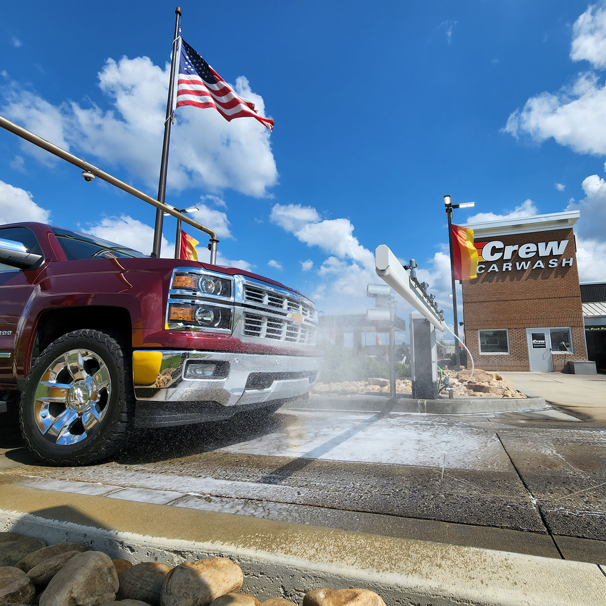 A red truck getting sprayed with bug pre-soak
