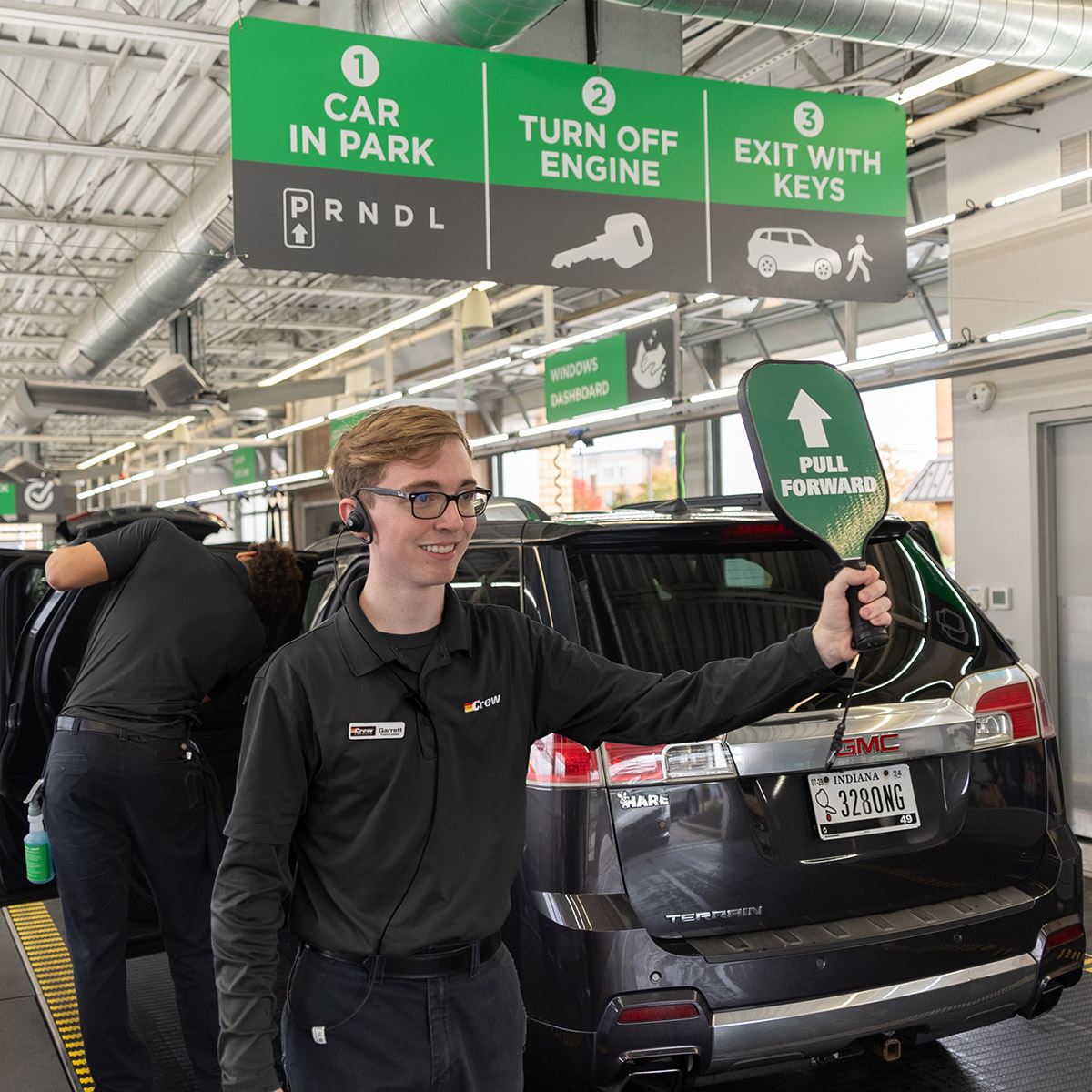 Crew Carwash team member directing a customer