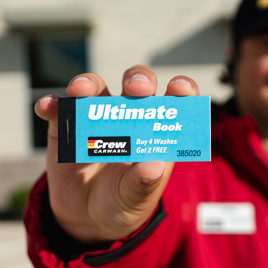 An employee holding an Ultimate wash book