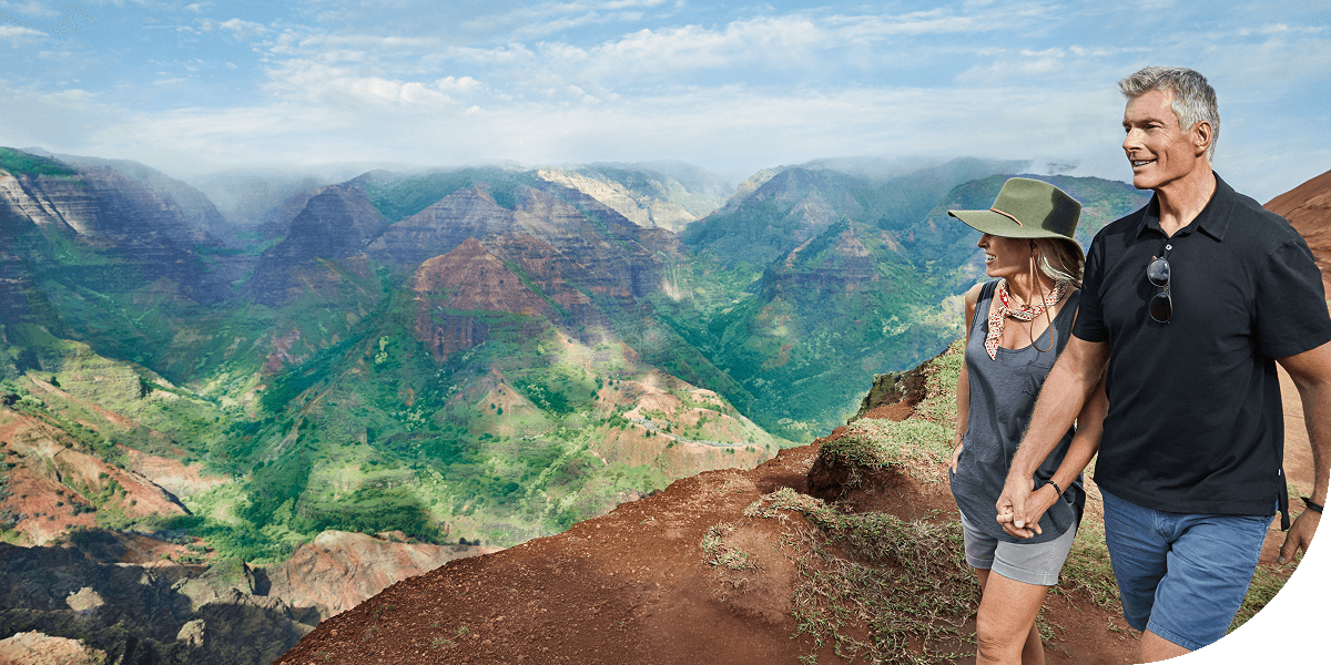 Couple holding hands walking along mountain trail, Kauai, Hawaii.