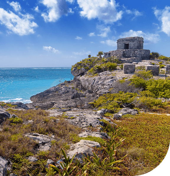 Ancient Mayan ruins perched on cliffs overlooking the Caribbean Sea.